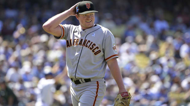 Giants pitcher Logan Webb smiles as he walks to the dugout.